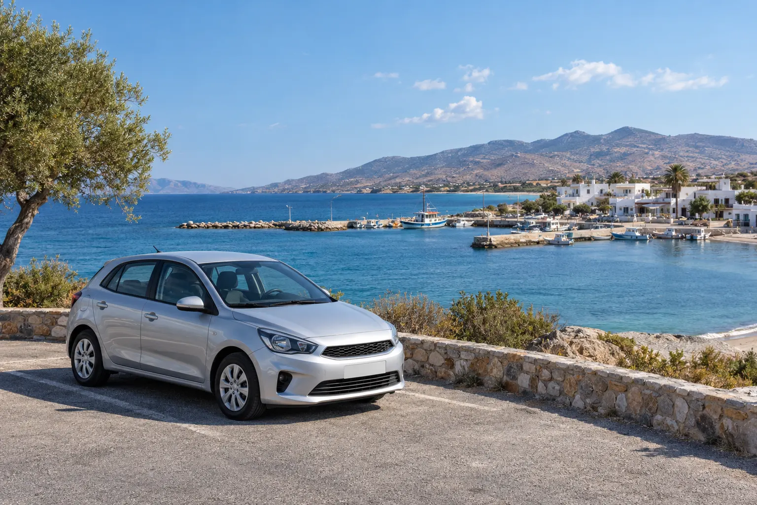 Silver car beside a small coastal harbour and white buildings